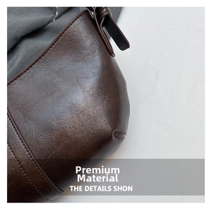 Close-up of dark brown leather texture and detailed stitching on the minimalist tote bag