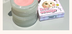 Detail view of pink peach cat-themed blush compacts and matte packaging boxes