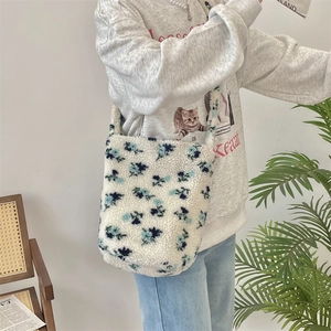Fleece bucket bag with blue floral patterns shown on a model for size and capacity