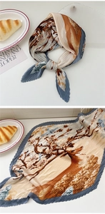 Detail of pleated silk scarf featuring vintage floral and bird prints in beige and navy