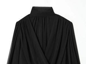 Detalle de una blusa negra de cuello alto con mangas de linterna y tejido plisado elegante