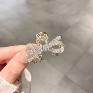 Cute golden metal hair claw clip featuring a rhinestone bowtie design for women