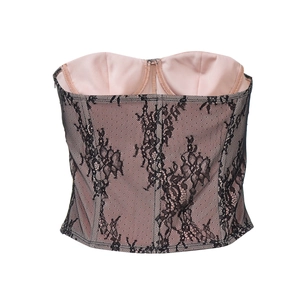 Détail d'un haut corset en dentelle noire avec doublure rose et baleines apparentes