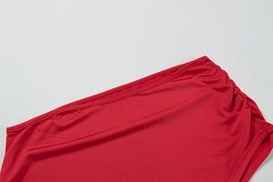 Detailed close-up of red elastic fabric with fine stitching and ruched waist design