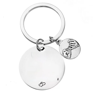 Detailed view of silver stainless steel keychain with romantic heart engraving and hand charm