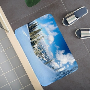 Detailed view of snowy mountain flannel floor mat on dark grey tiles with blue slippers