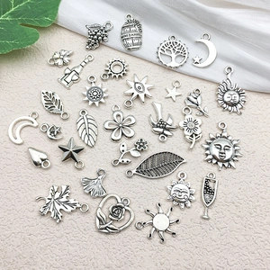Detail of vintage silver alloy charms featuring sun, moon, and rose for DIY jewelry