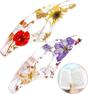 Detail of clear resin page holder with dried flowers and gold leaf for hands-free reading