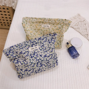 Macro detail of cotton floral cosmetic bags with zip closure and fabric labels