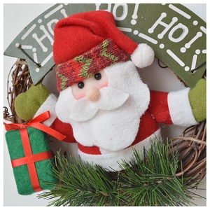 Detail of plush Santa Claus wreath with pine needles and Ho Ho Ho wooden sign decor