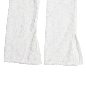 Détail d'une manche en dentelle blanche avec fente et motifs floraux délicats