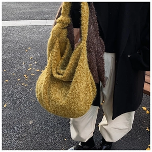 Detail of ginger wool tote bag with knot shoulder strap and textured fabric in autumn park