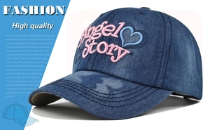 Dettaglio del ricamo Angel Story su berretto da baseball in denim blu scuro lavato