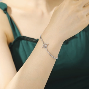 Elegant silver stainless steel bracelet with cutout geometric clover design on model