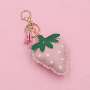 Pink faux leather strawberry keychain with gold hardware and a pink tassel charm