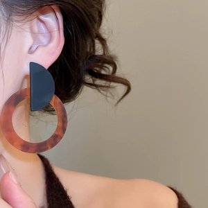 Close-up of model wearing retro resin hoop earrings with amber tortoiseshell texture