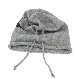 Detail of grey knitted drawstring beanie featuring close-up texture and black jacquard