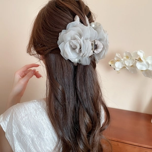 Vue détaillée d'une pince à cheveux rose en résille grise portée sur une coiffure