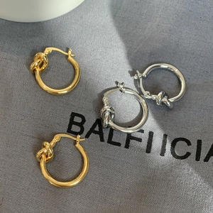 Minimalist knotted metal hoop earrings in gold and silver finish with polished texture