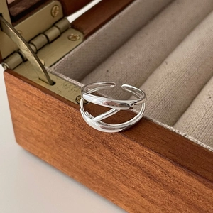 Macro detail of adjustable 925 sterling silver multilayer ring on wooden jewelry box