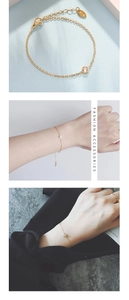 Detail of gold titanium bracelet featuring K18 engraved tag and bezel-set zircon stone