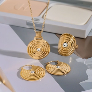 Detail of gold jewelry set with concentric circles and sparkling center crystals