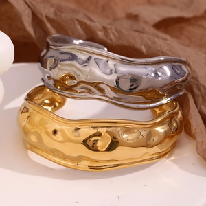 Detail showing wavy textured 18K gold and silver plated stainless steel wide cuff bracelets