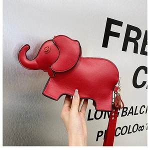 Detail of red leather elephant shaped handbag with tassel charm and thin shoulder strap