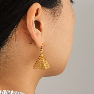 Detailed view of vintage 18K gold plated pyramid earrings with Eye of Horus embossing