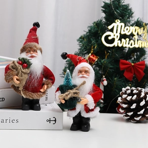Detail of plush standing Santa Claus figurines with miniature trees for holiday decor