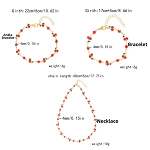 Detailed view of cherry jewelry set featuring red beads and gold chain with measurements