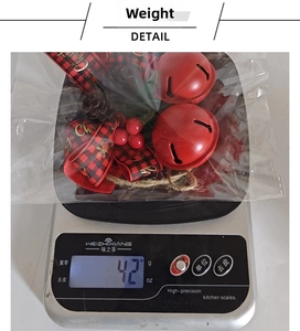 Detail showing Christmas bell weight at 42g on a kitchen scale with festive bow décor