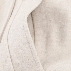 Women's minimalist short wool coat in cream white showing premium fabric texture