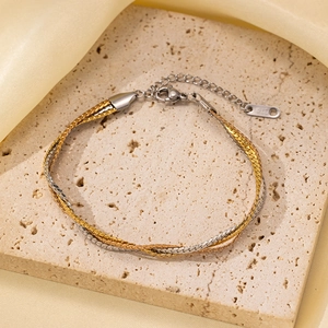 Detalle de pulsera trenzada de acero inoxidable bicolor con cierre de mosquetón ajustable