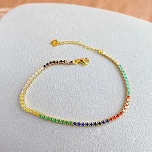 Macro view of rainbow tennis bracelet in gold finish with S925 heart charm detail