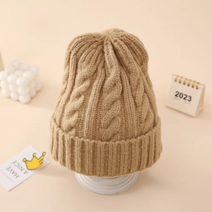 Close-up of camel cable knit beanie showing thick rolled cuff and soft wool texture