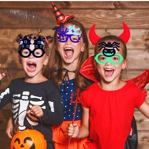Kids wearing Halloween themed glowing glasses featuring spider and ghost designs for parties