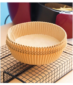 Macro detail of round non-stick air fryer paper liners in natural brown color