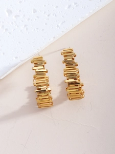 Detailansicht goldener geometrischer Ohrstecker mit gestapelten rechteckigen Metallmodulen