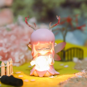 Close-up of cute pink fairy night light with glowing crystal ball and deer antlers