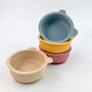 Stack of four colorful bear-shaped silicone baby suction bowls in blue, yellow, pink and beige