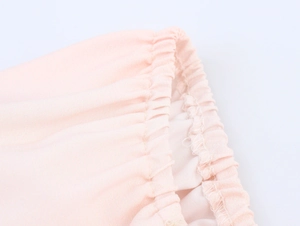 Dettaglio del polsino elastico del vestito rosa con cuciture doppie e trama tessuta