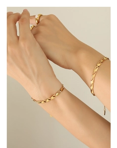Detail of 18k gold plated hollow chain bracelet and pearl ring on female model hand