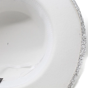Detail view of white wool top hat featuring sparkling silver glitter brim and sweatband