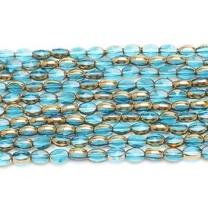 Close-up of faceted 6x8mm crystal glass beads in blue and gold for jewelry making