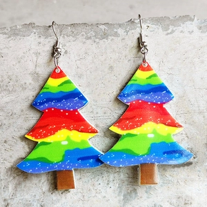 Rainbow striped Christmas tree earrings with snow dot pattern on stone background
