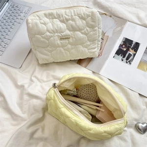 Macro detail of heart-quilted texture and spacious interior of the soft makeup bag