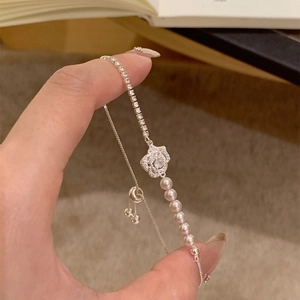 Macro shot of rose-shaped zircon setting with elegant pearls and adjustable chain