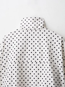 Dettaglio della spalla posteriore e del colletto di questo completo bianco a pois