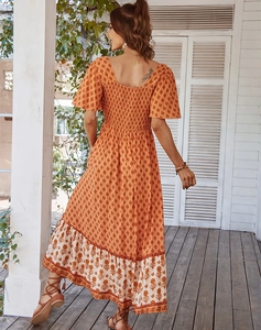 Detail of the back design on an orange floral maxi dress with ruffle sleeves and V-neck